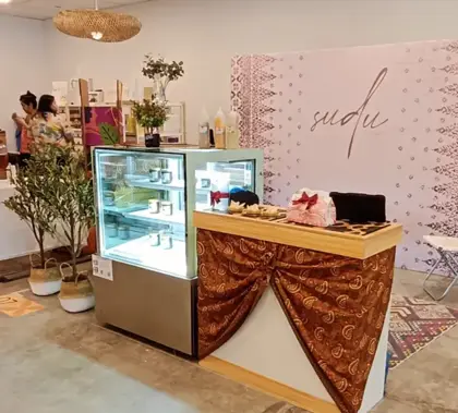 AANRS cake chiller rental Singapore, glass display of small jars standing next to a fabric-draped serving counter at an indoor pop-up