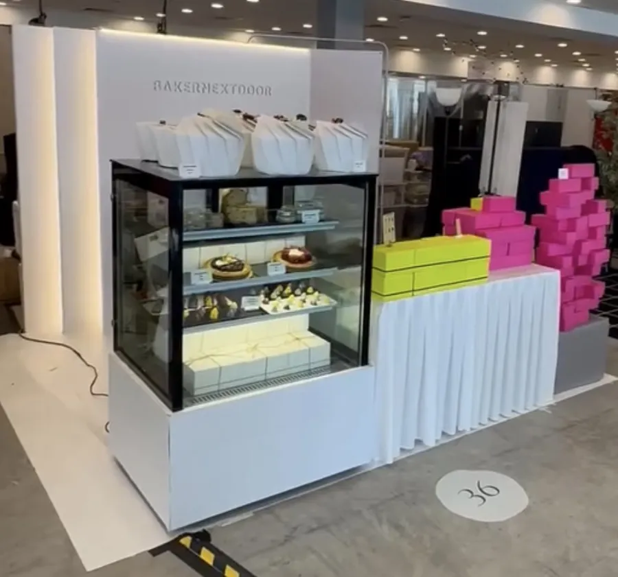 AANRS cake chiller rental Singapore, glass display of cakes and tarts at a white bakery stand in an event hall
