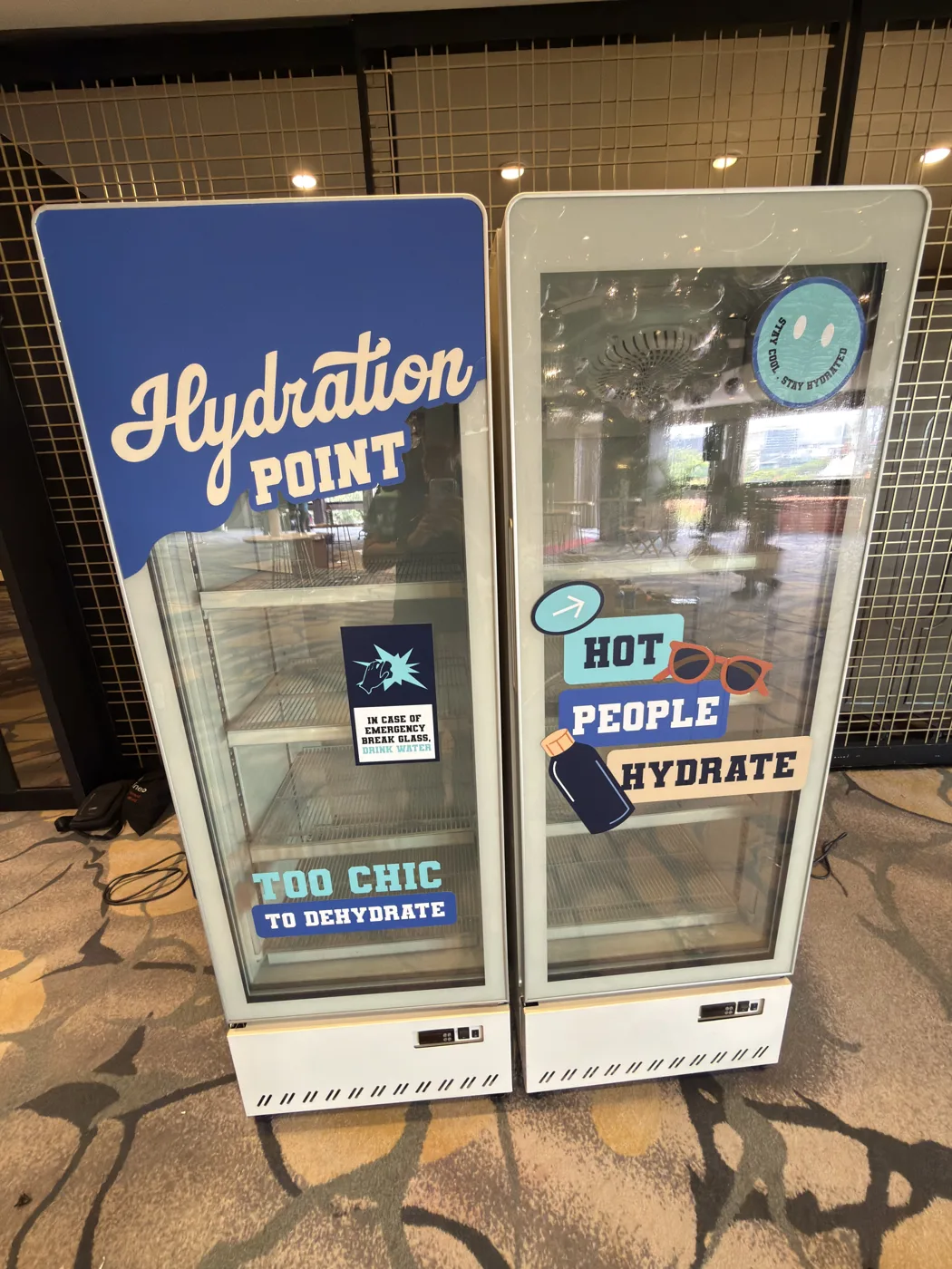AANRS drink chiller rental Singapore, two chillers wrapped in blue hydration-point graphics standing in a carpeted event foyer